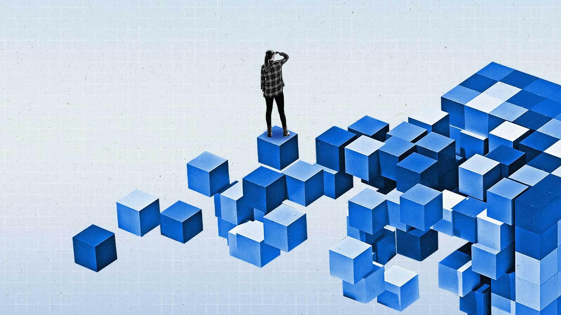 Women stands on a series of blue building blocks and looks into the distance.