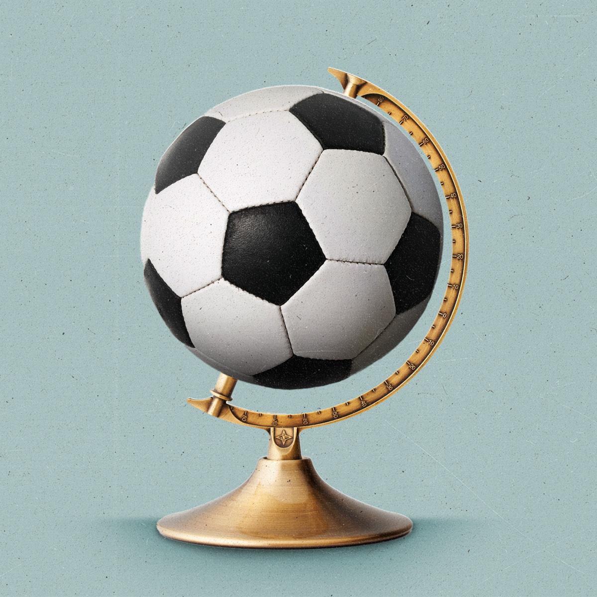 A soccer ball sits on a brass globe stand.