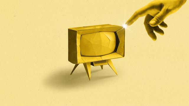 A gold hand reaches out and touches an origami TV.