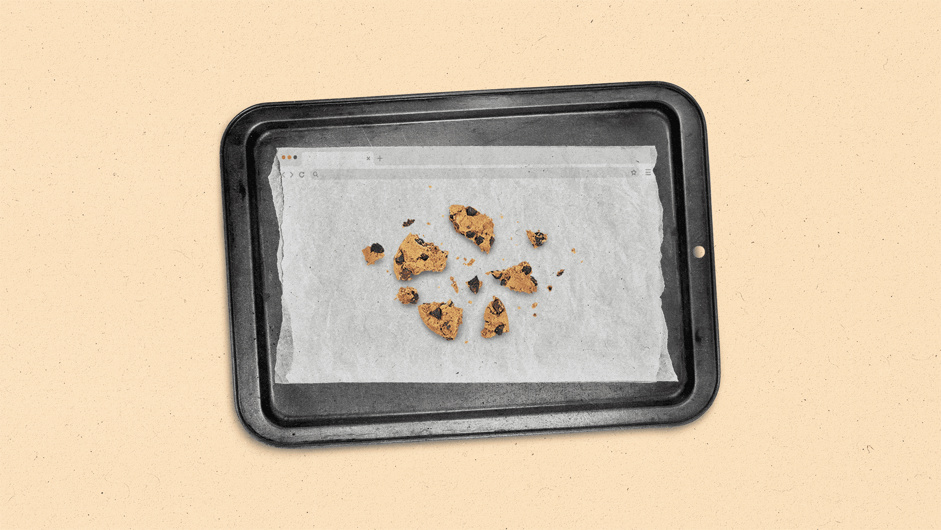 A broken chocolate chip cookie sits on a browser window parchment paper lined baking sheet.