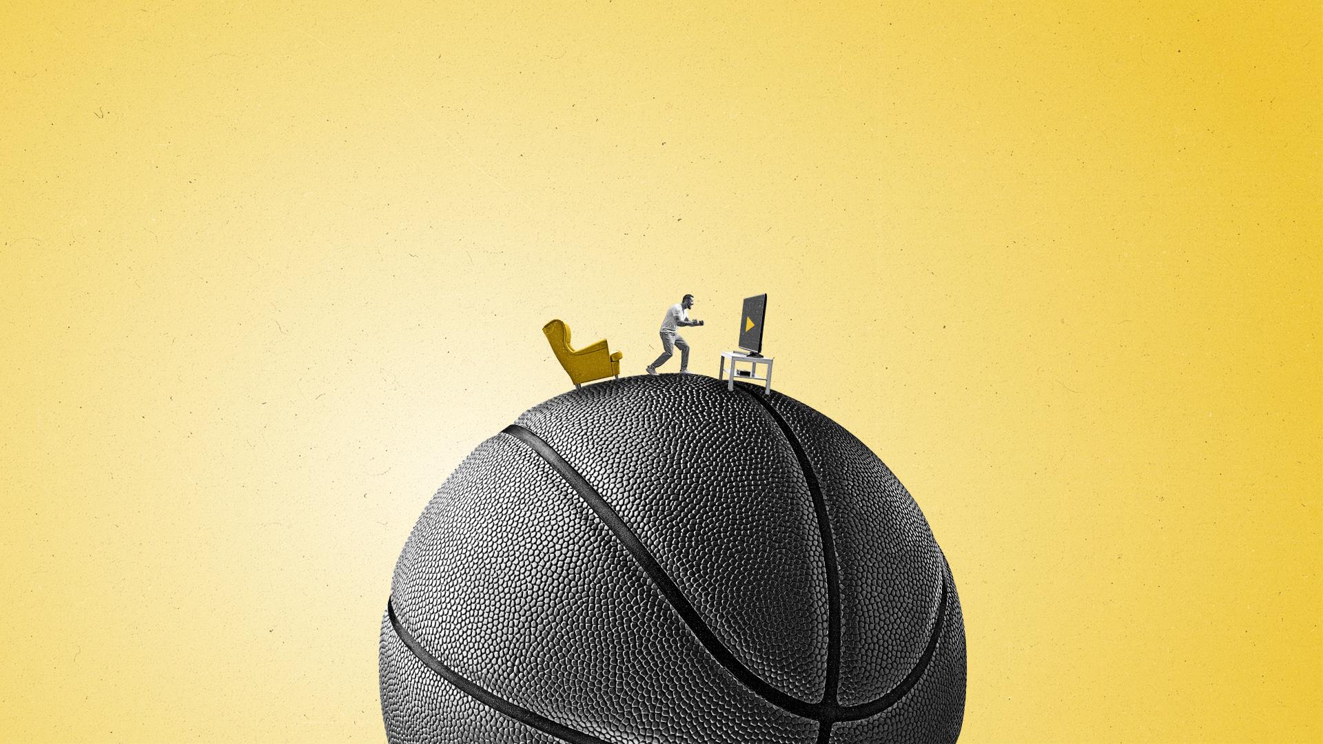 A man cheers on a game on a connected TV on a giant basketball.
