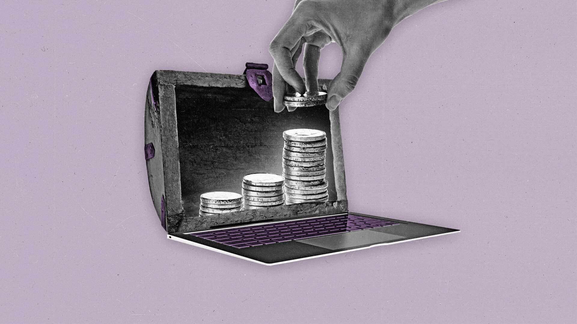 A hand stacking coins into a treasure chest lid acting as a laptop screen.