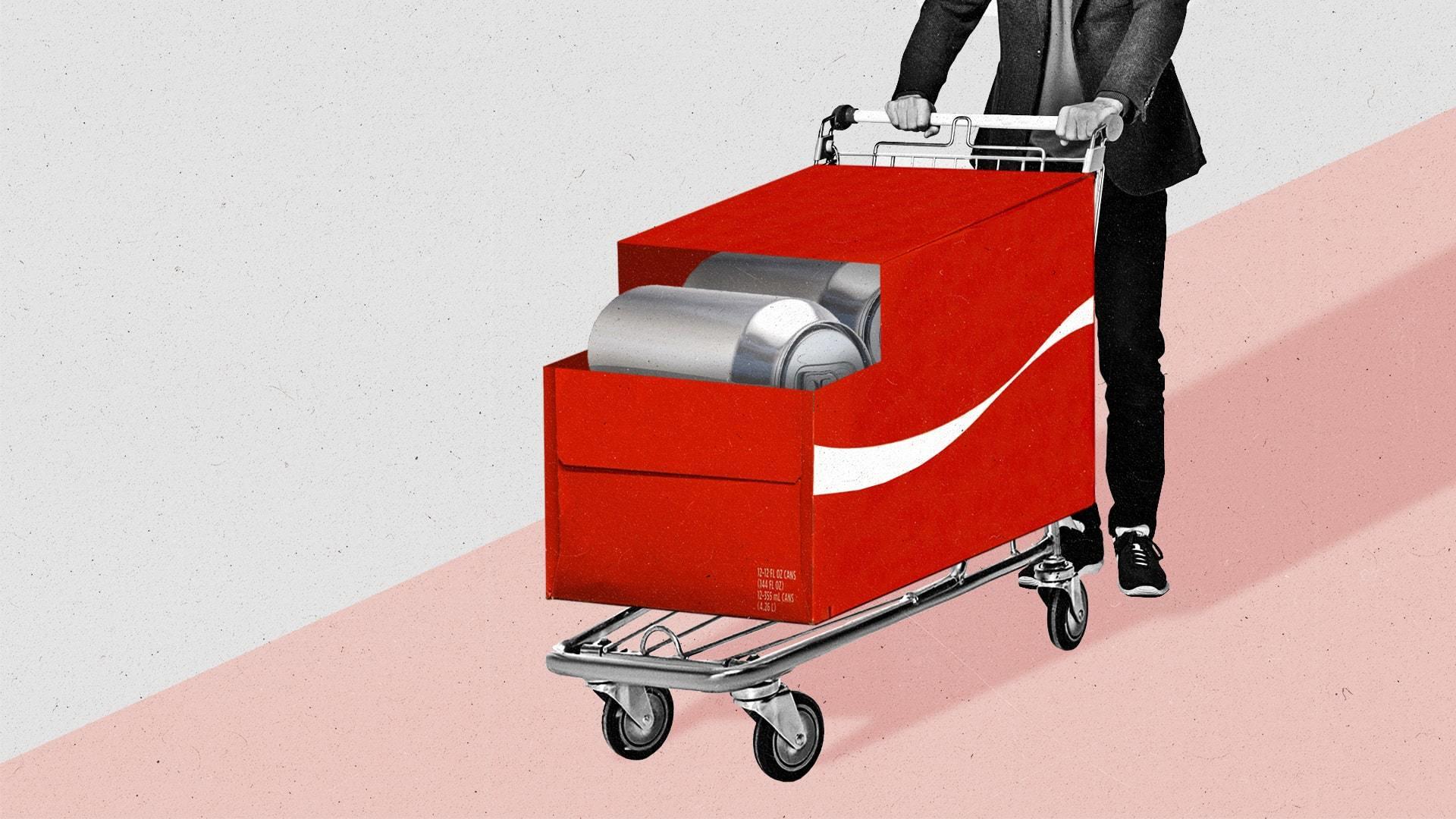 An oversized red box of soda cans, complete with shopping cart wheels, a handlebar, and a white ribbon graphic, is pushed by a man in a suit.