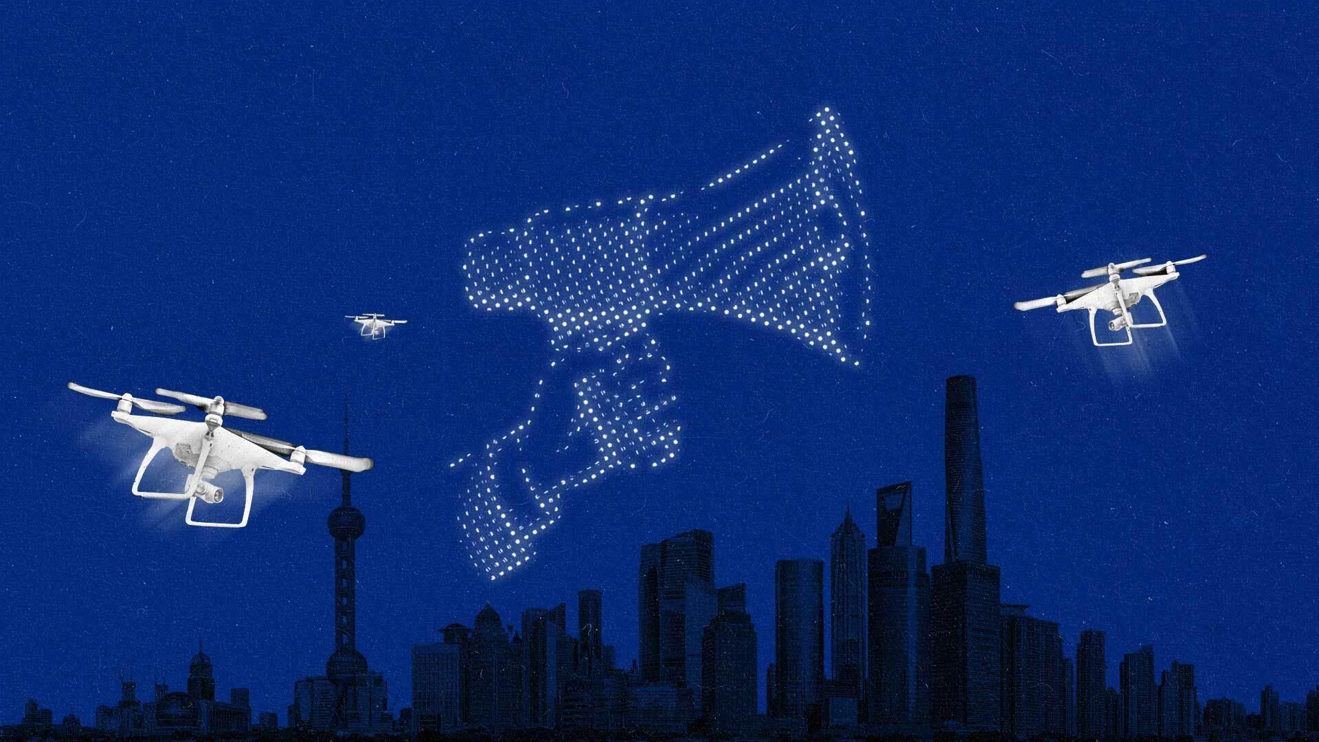 A series of drones form a hand holding a megaphone above the Shanghai skyline.