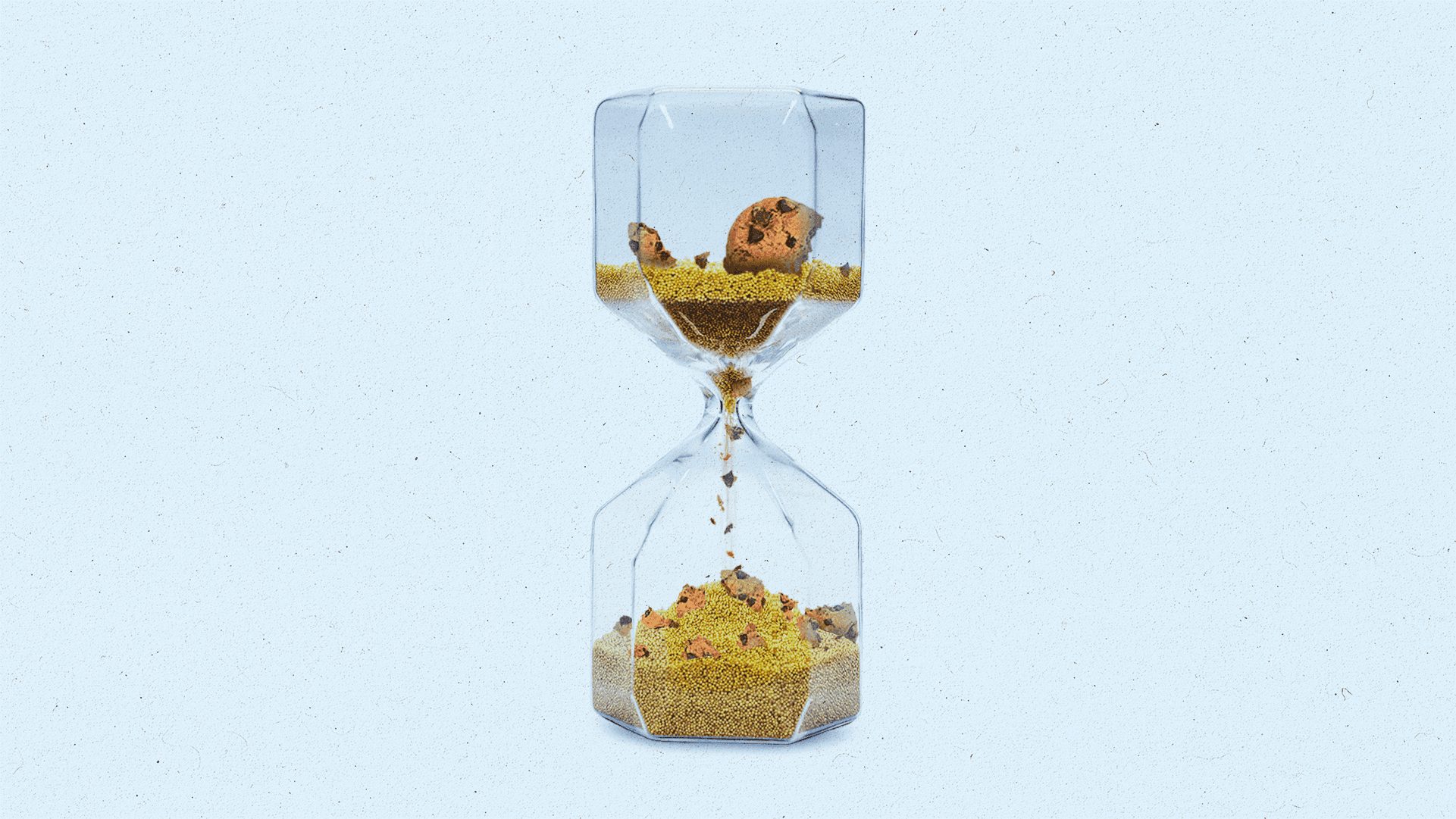An hourglass running out of time with cookie pieces and crumbs mixed into the sand.