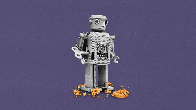 Tin toy robot standing on top of crushed chocolate chip cookie pieces.