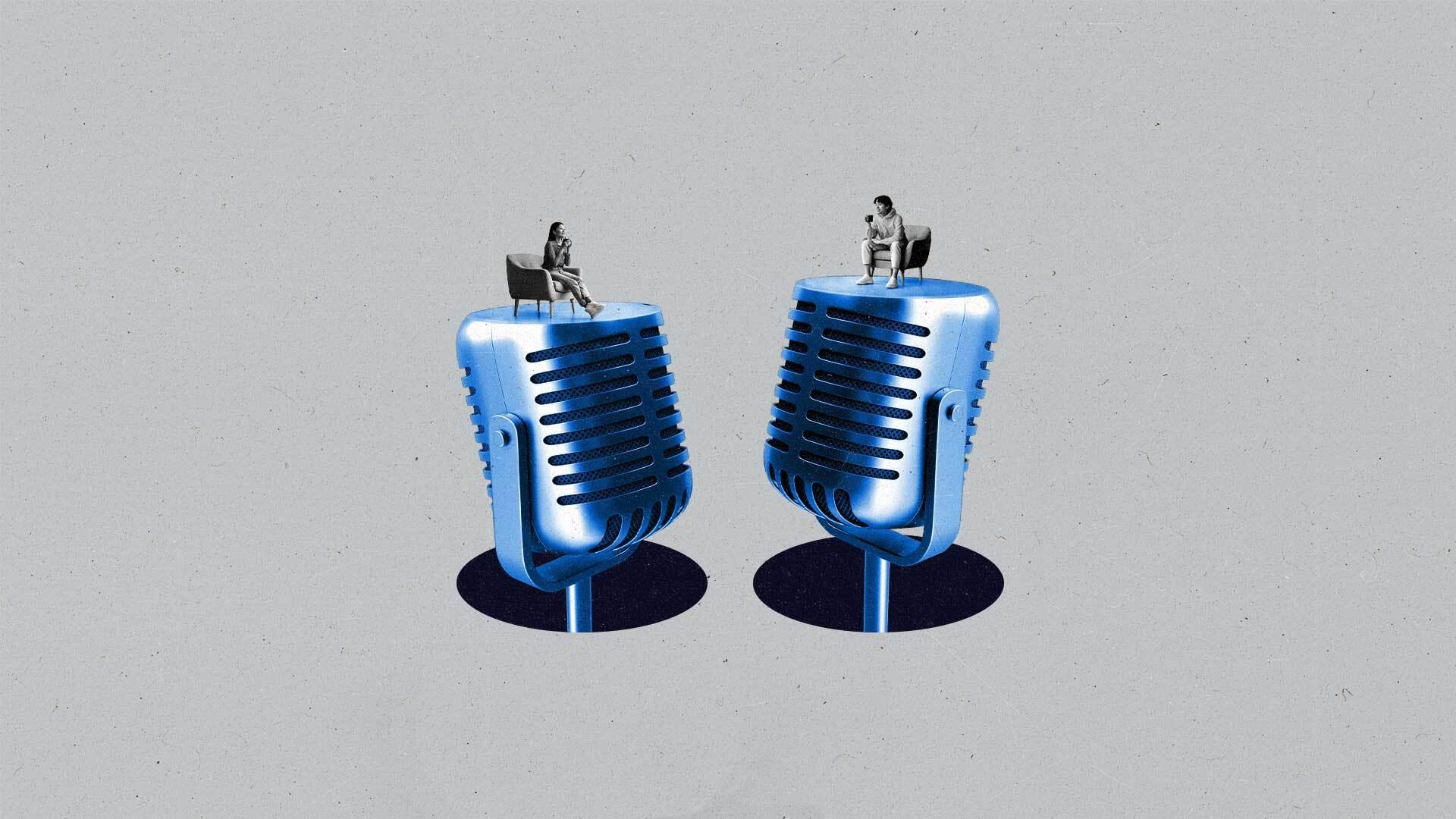 Two podcasters chat on a stage made out of two giant podcast mics.