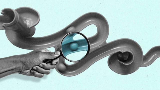 A series of balls follow a path as a hand holding a looking glass examines a segment of it in blue.