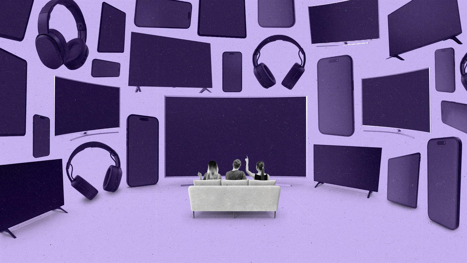 People sitting on a couch facing towards a large wall of tvs, phones, tablets, and headphones.