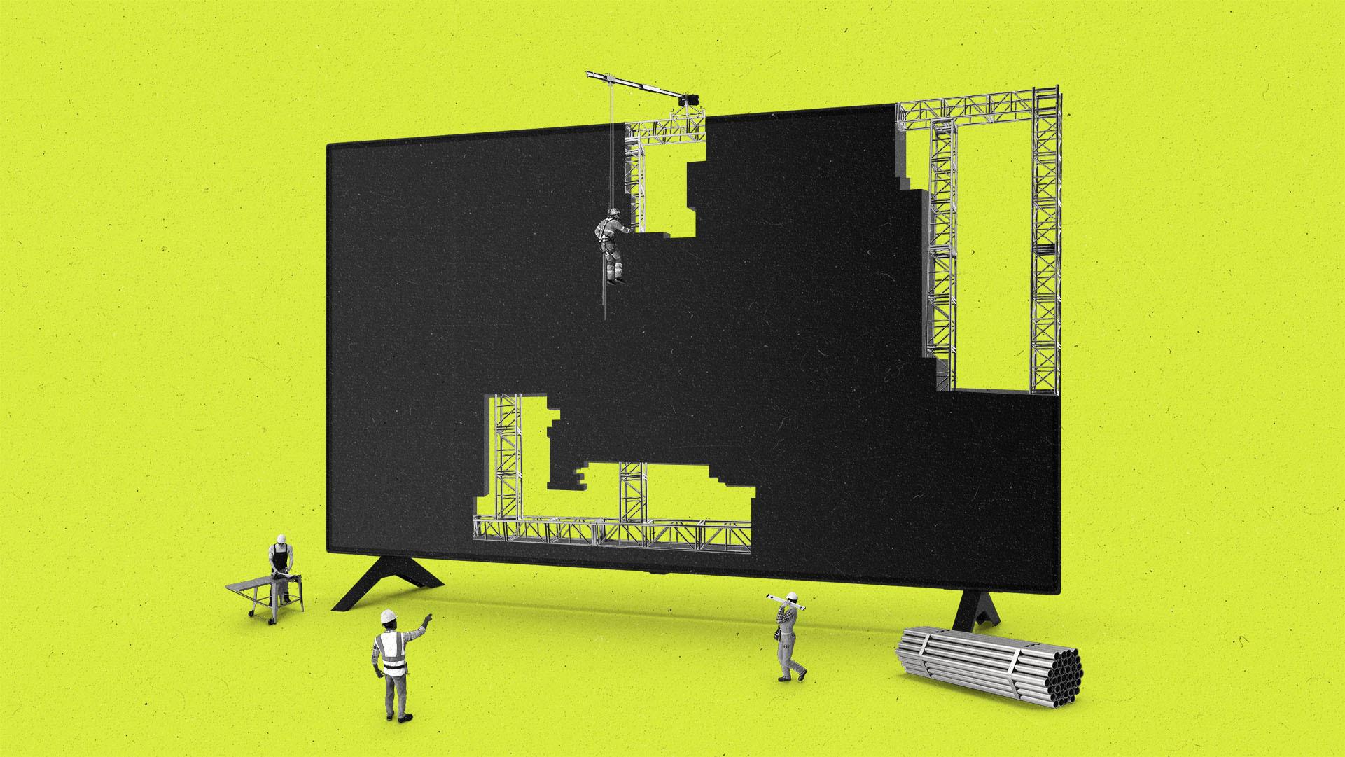 Small construction workers work around a large, partially-built flatscreen TV