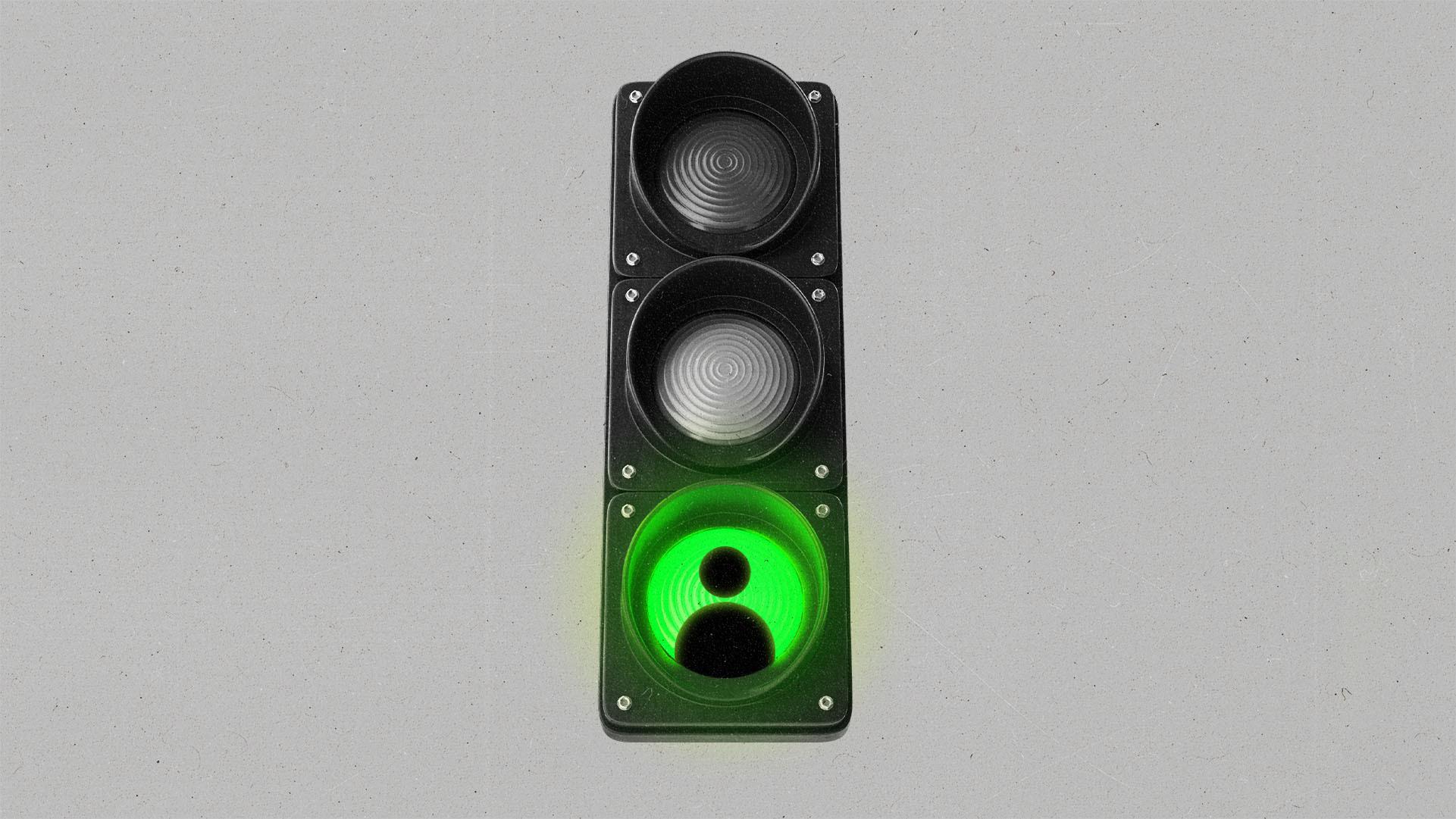 A green traffic light with a person profile silhouette in the green light.