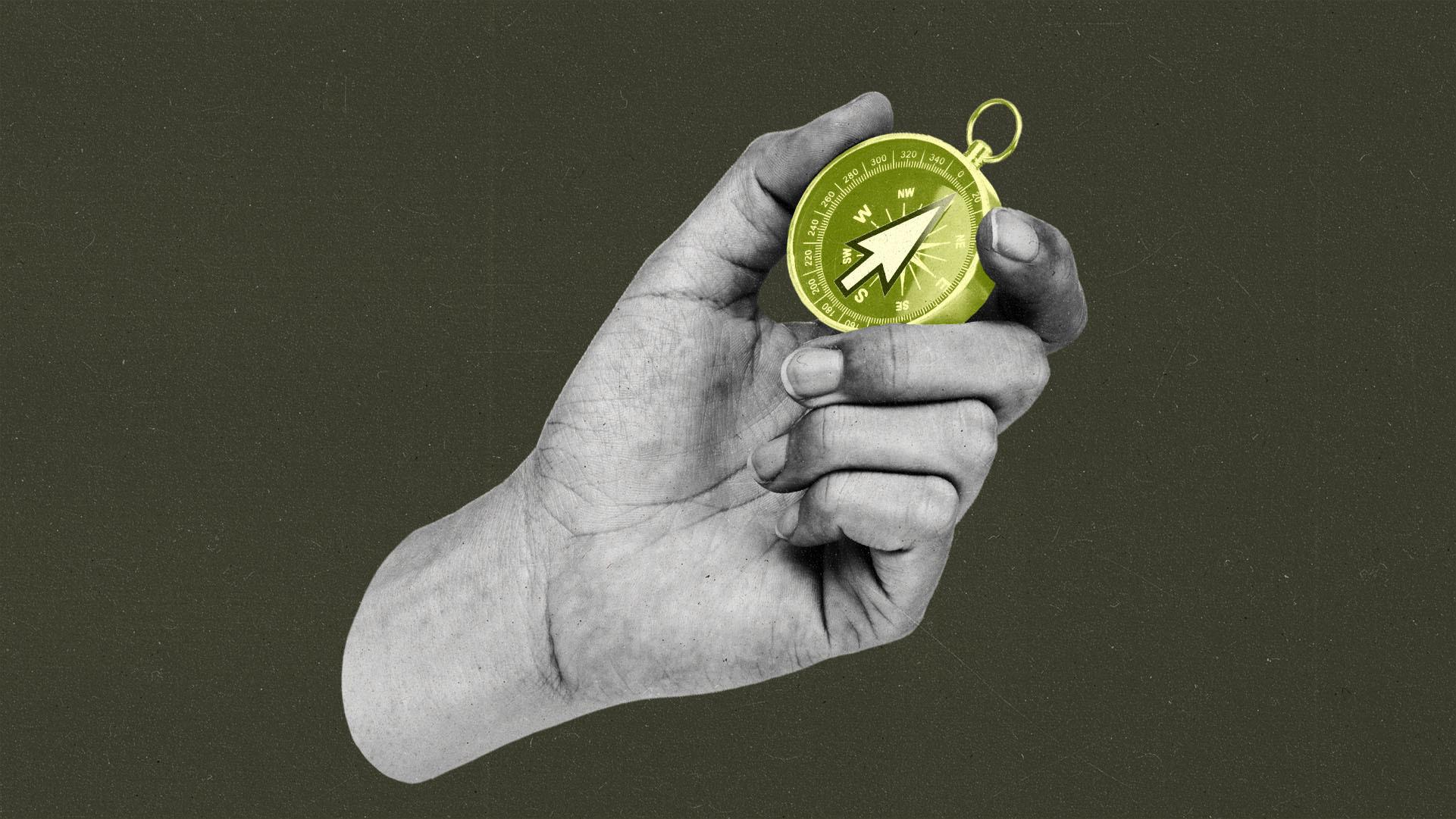 A black & white hand holding a golden yellow compass, with a cursor inside pointing north.