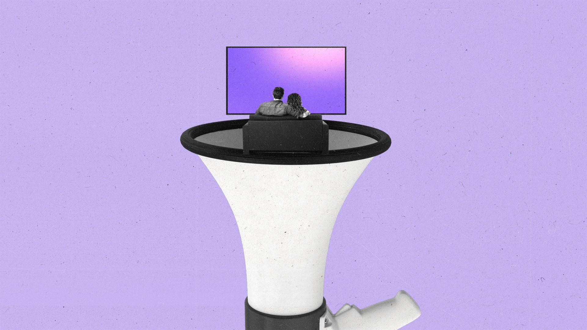 Two people watching TV while sitting on top of a megaphone.