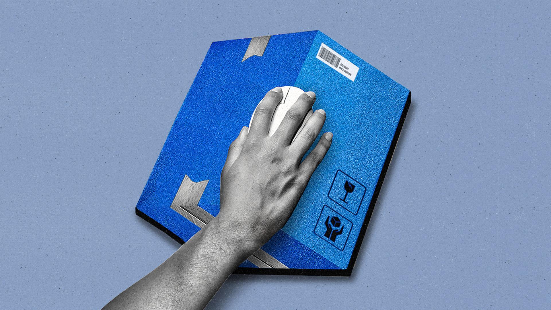 Hand holding a computer mouse hovers over a cardboard shipping box.
