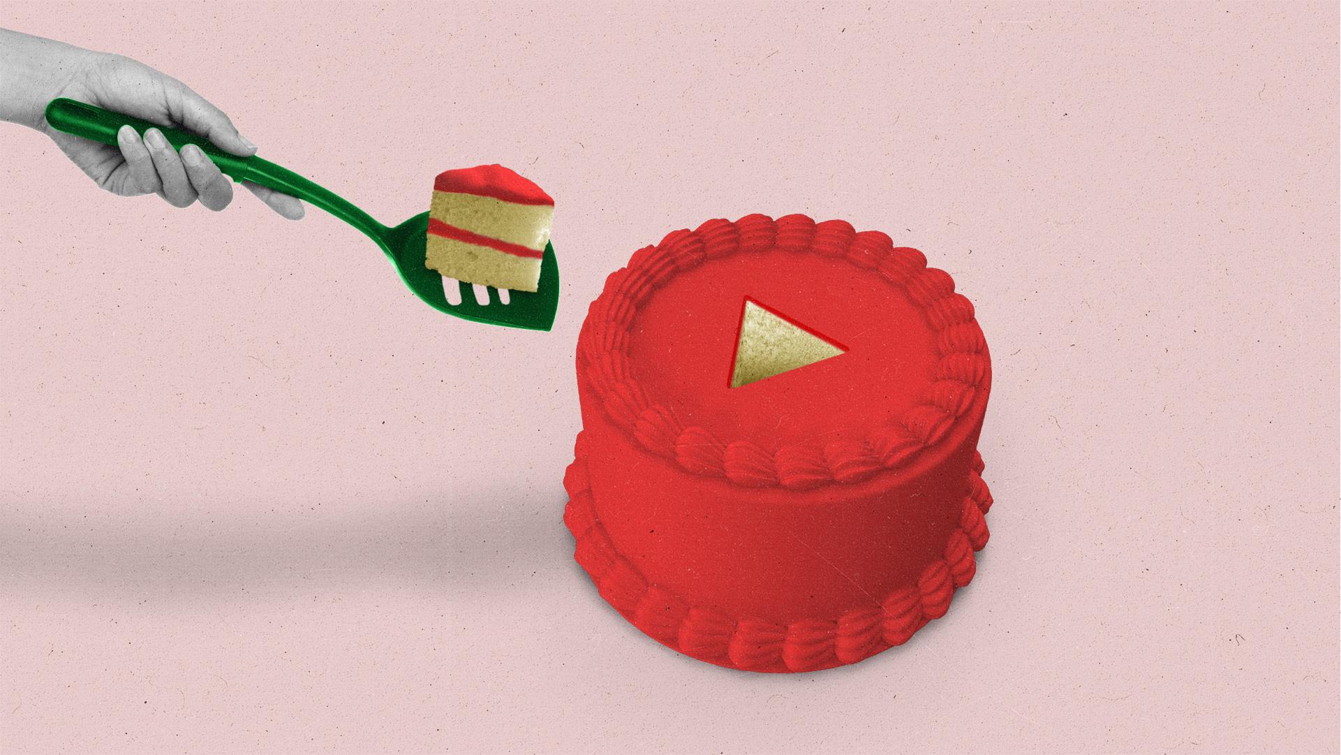 Hand taking a play button-shaped slice of cake out of a red cake using a green spatula.