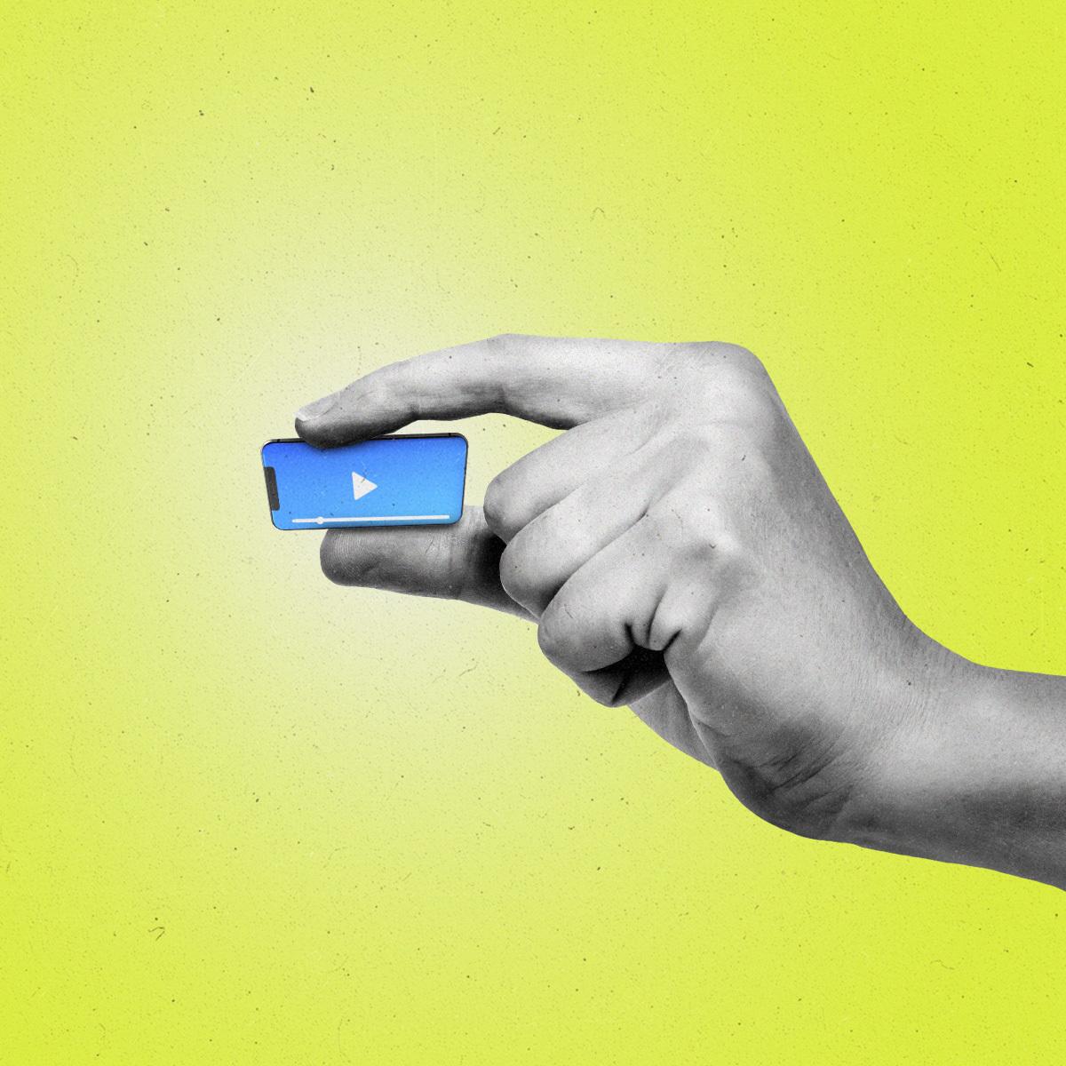 Hand pinching a miniature smartphone that's playing video content.