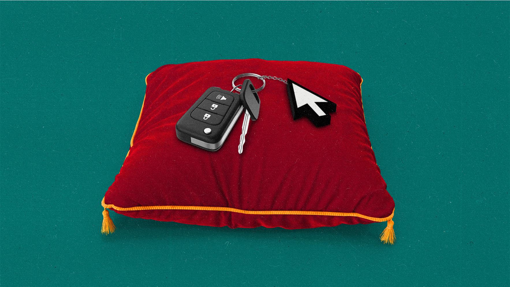 Car keys with a cursor on the keychain, resting on a red velvet pillow.