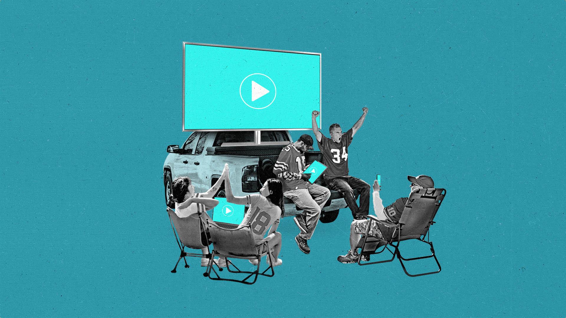 Sports fans sitting in lawn chairs tailgating a truck with a TV in the truck bed.