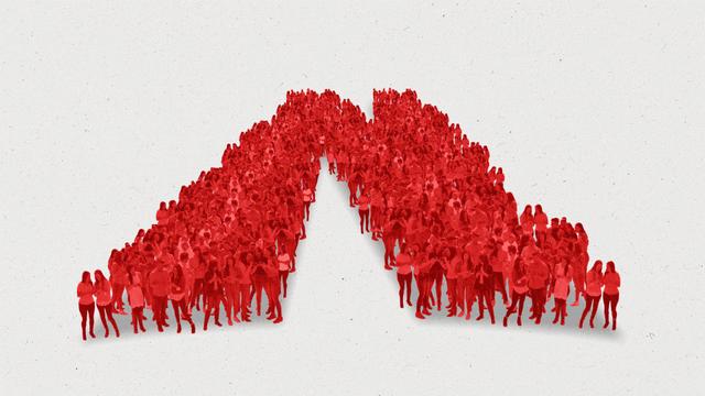 A crowd of all-red people stand in the shape of an "N".